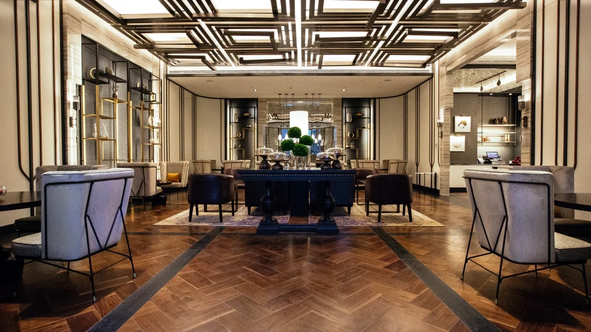 Fairmont Quasar İstanbul — geometrik tavan, metal raflar ve salon mobilyaları